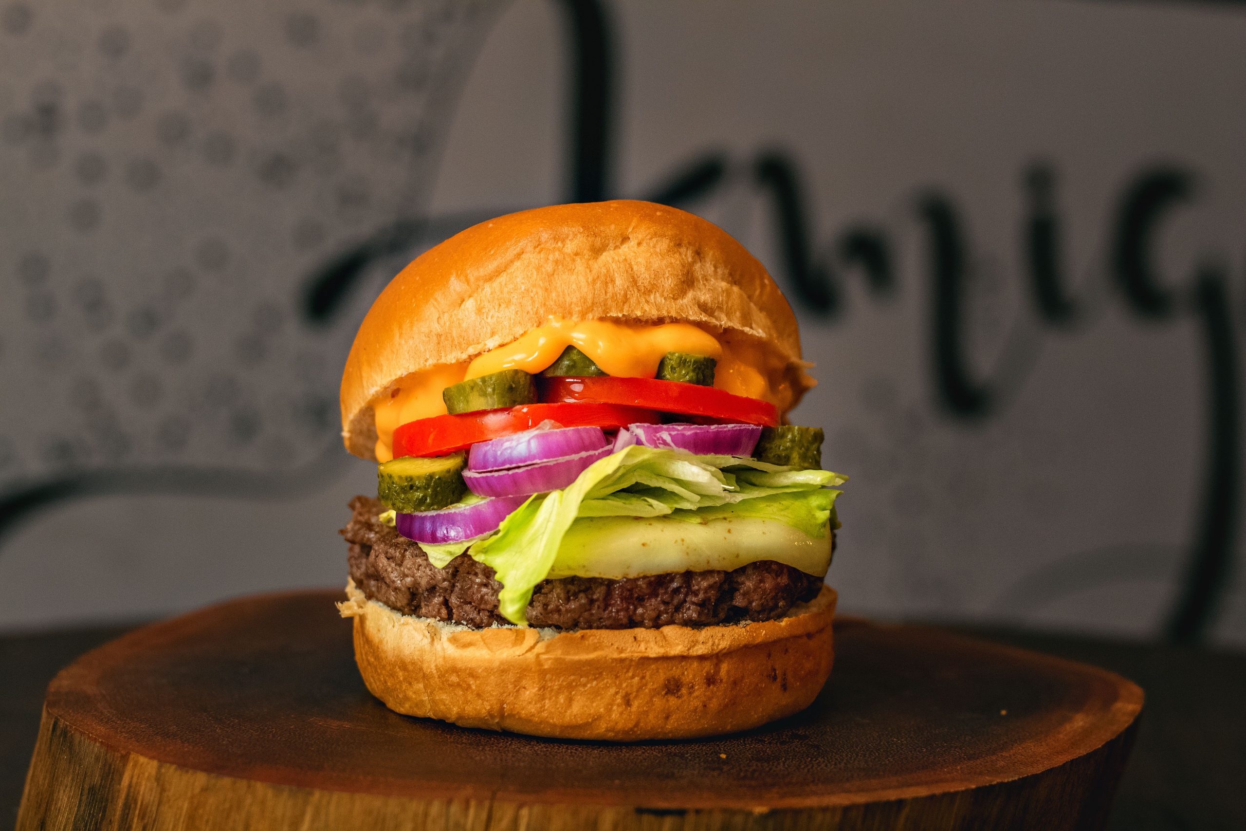 pexels photo 10701947 10701947 A close-up of a mouthwatering cheeseburger with lettuce, tomato, and pickles.